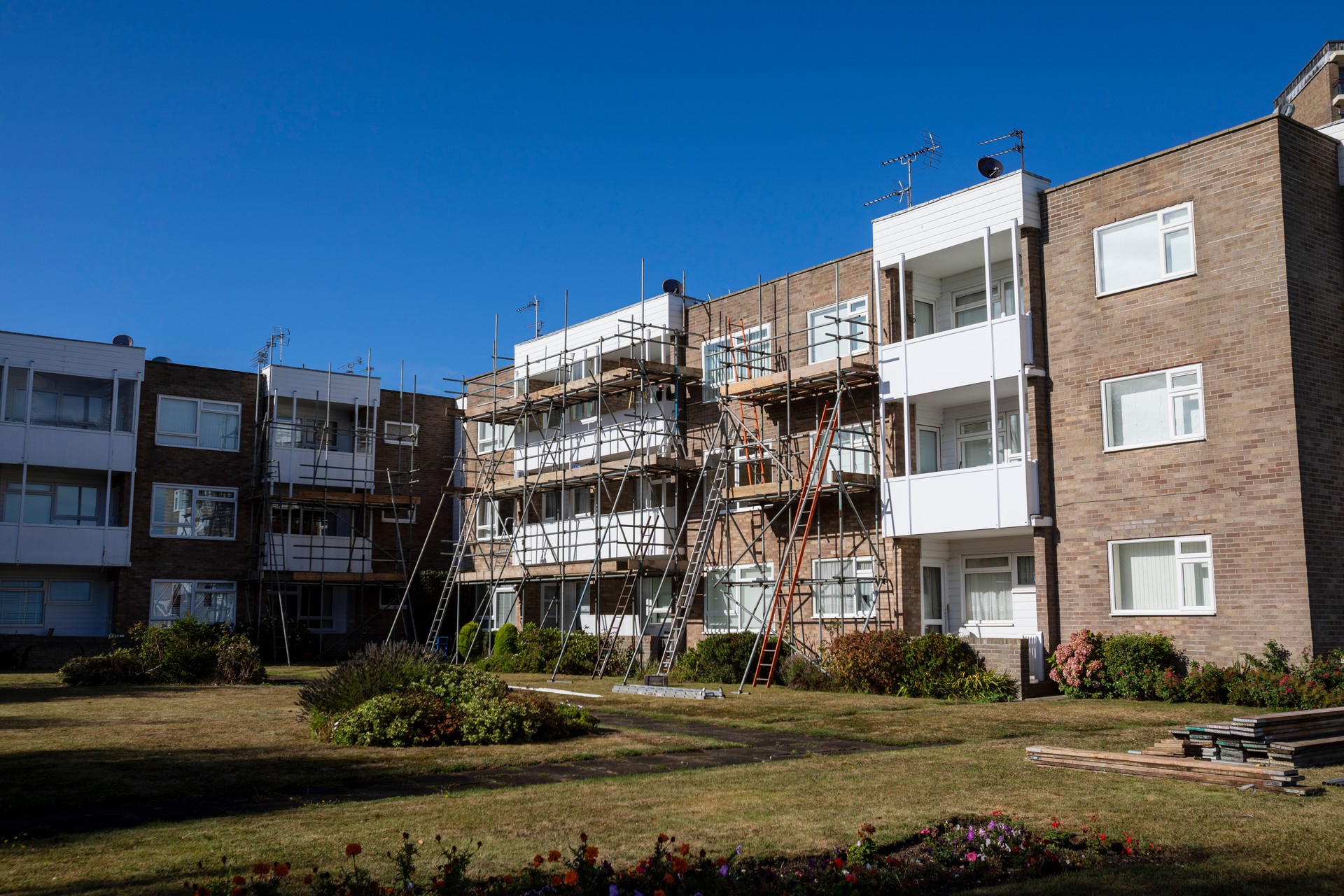 Scaffolding around apartment buildings with a blue sky